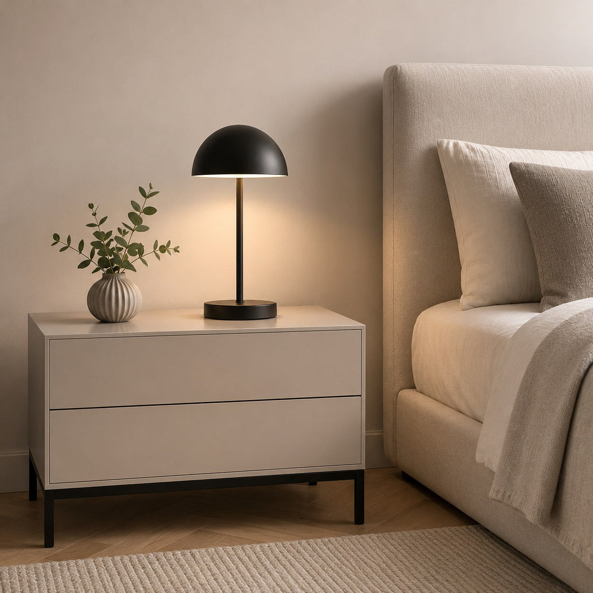 Table de chevet moderne blanche avec deux tiroirs et piètement noir dans une chambre contemporaine.