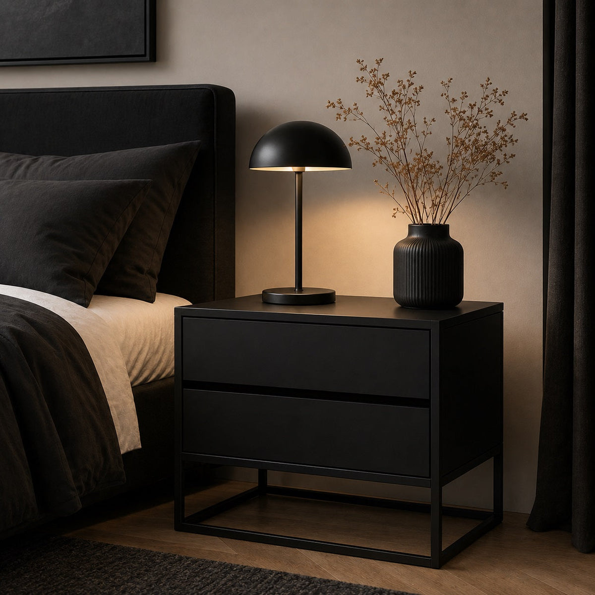 Table de chevet noire avec deux tiroirs et structure métallique dans une chambre au style contemporain.