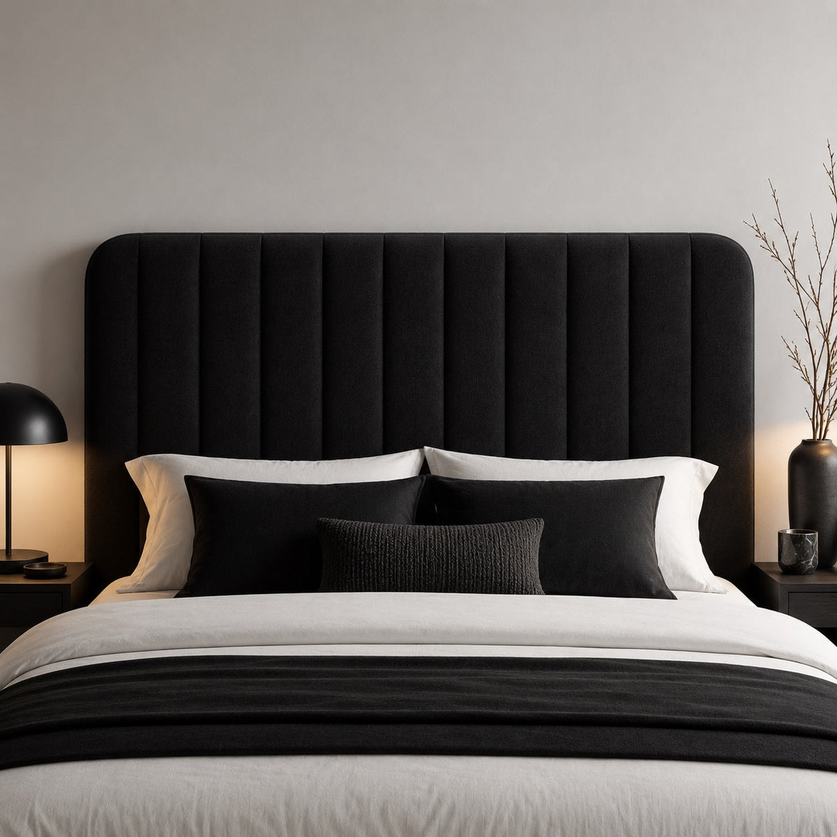 Tête de lit noire rembourrée à panneaux verticaux dans une chambre contemporaine au style minimaliste.