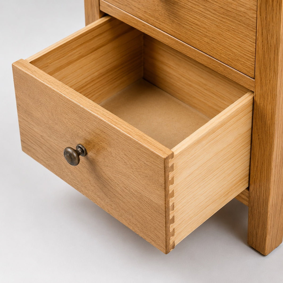 Détail d’un tiroir ouvert de commode 5 tiroirs en bois, avec rangement spacieux et finition naturelle soignée.