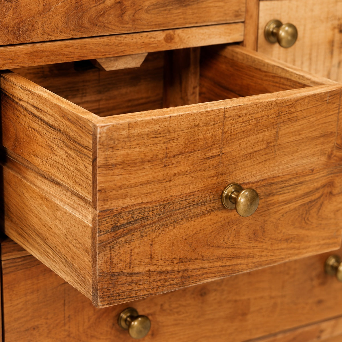 Tiroir ouvert de la commode en bois 5 tiroirs, avec rangement profond et bouton métallique finition laiton.
