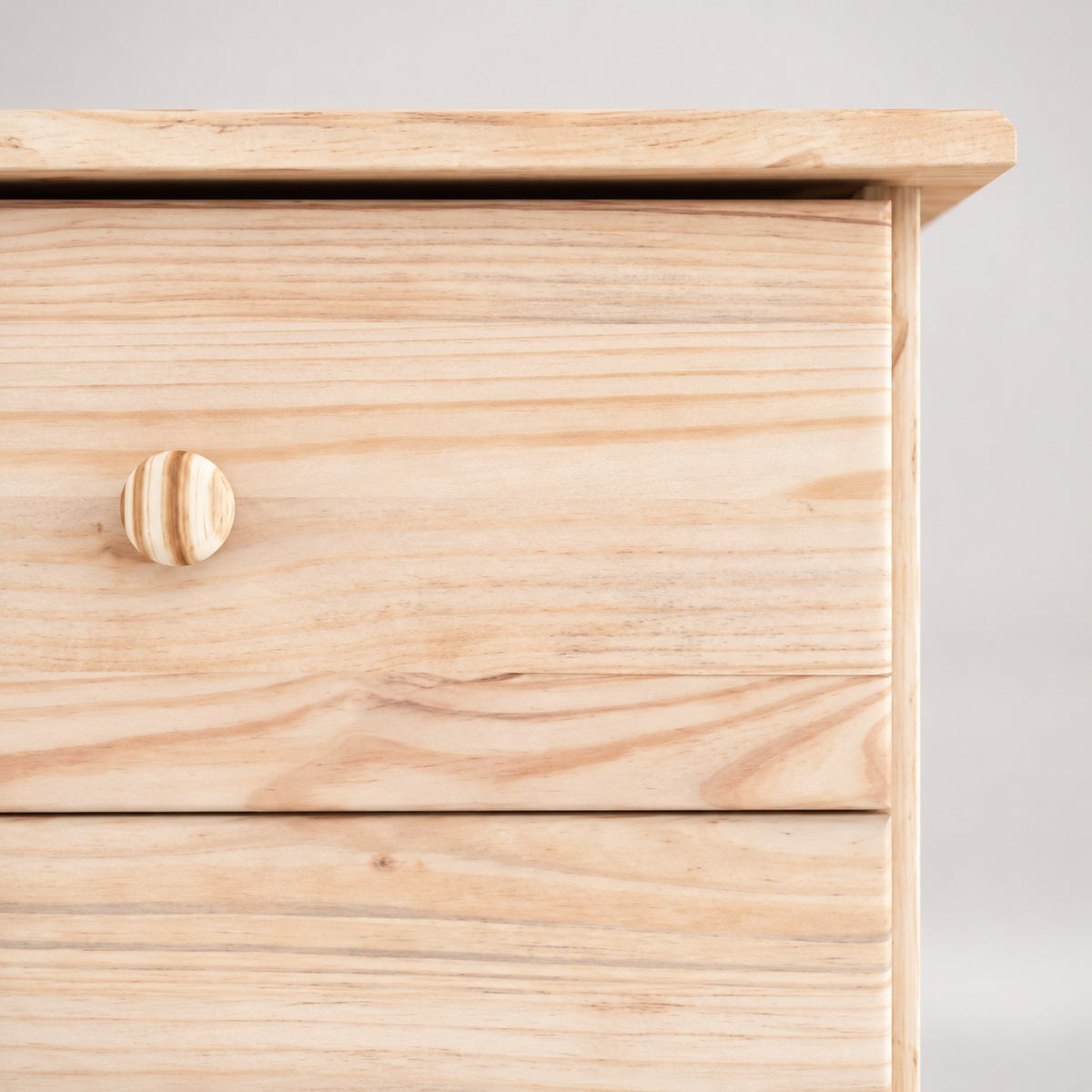 Détail de la commode en bois 7 tiroirs mettant en valeur la finition naturelle et les poignées en bois massif.