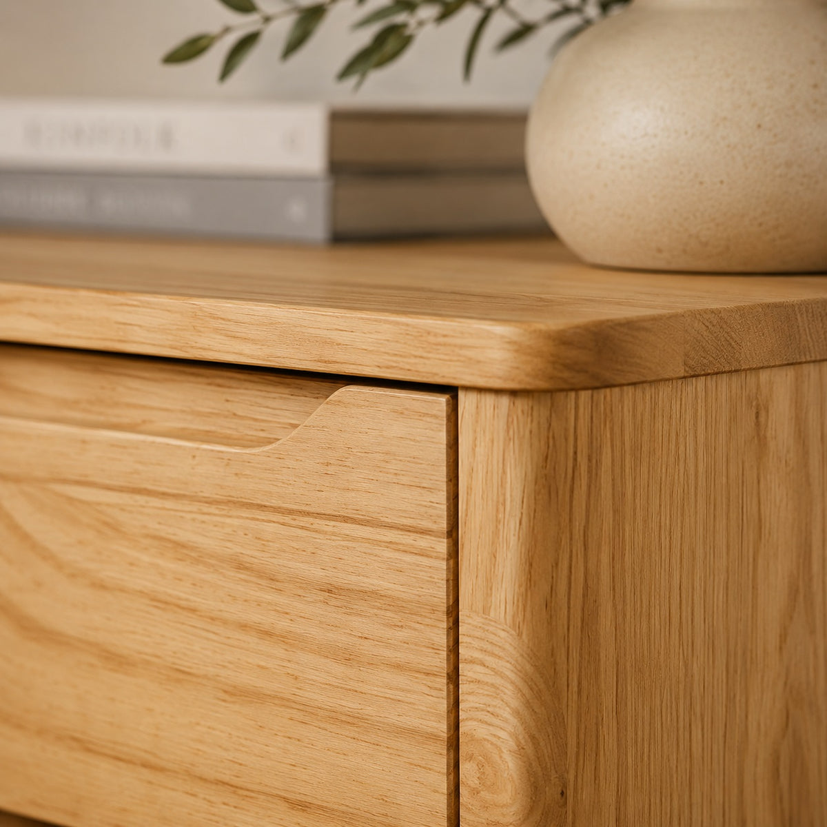 Détail de la commode en bois Zelio, veinage naturel, plateau arrondi et poignée intégrée au tiroir