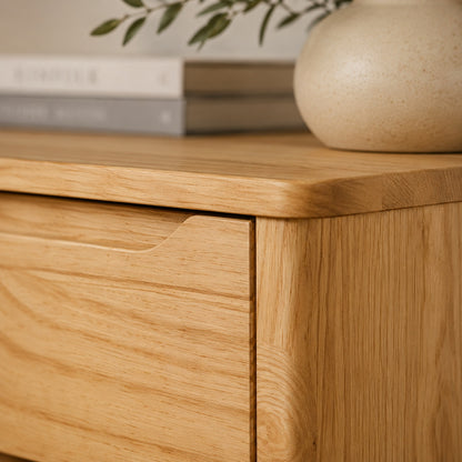 Détail de la commode en bois Zelio, veinage naturel, plateau arrondi et poignée intégrée au tiroir
