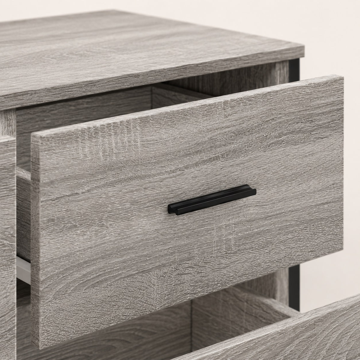 Détail d’un tiroir de la commode grise Oslo avec finition bois texturée et poignée noire