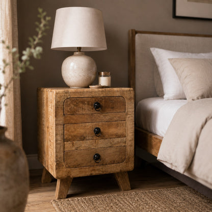 Table de chevet avec tiroir en bois massif dans une chambre chaleureuse au style naturel et authentique.