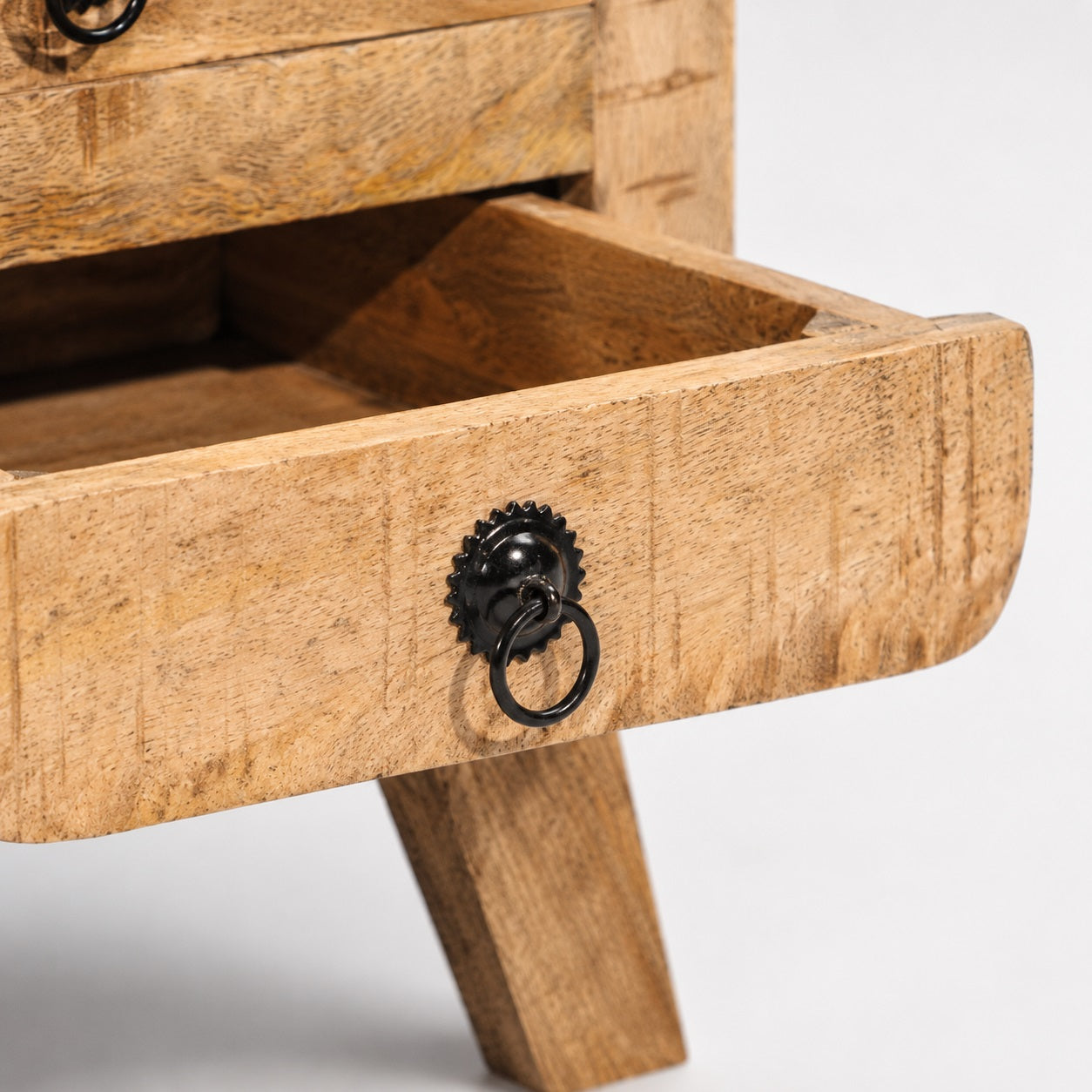 Zoom sur le tiroir d'une table de chevet avec tiroir en bois et poignée métallique de style vintage.