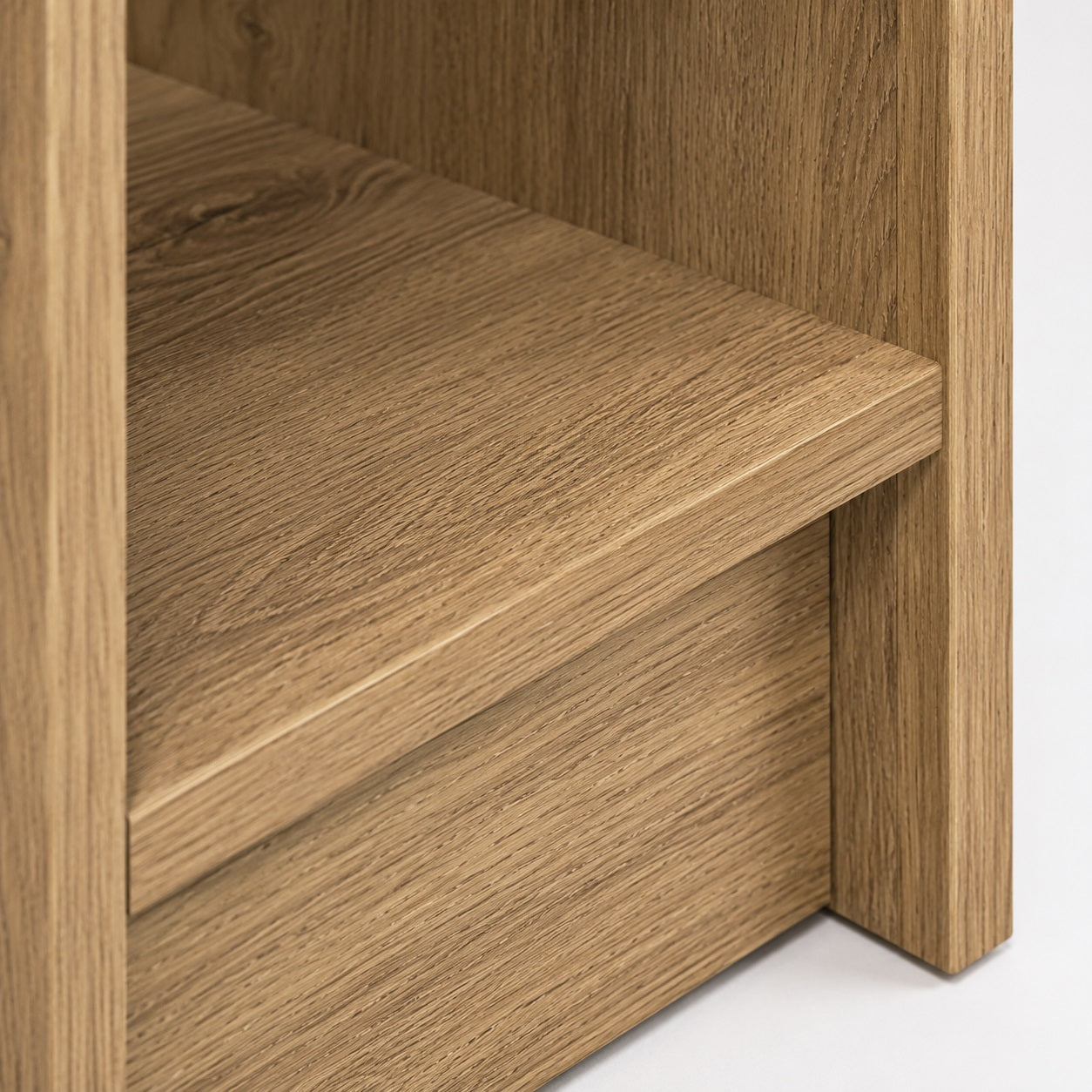 Zoom sur la niche d'une table de chevet en bois haute avec finition effet chêne et rangement pratique.