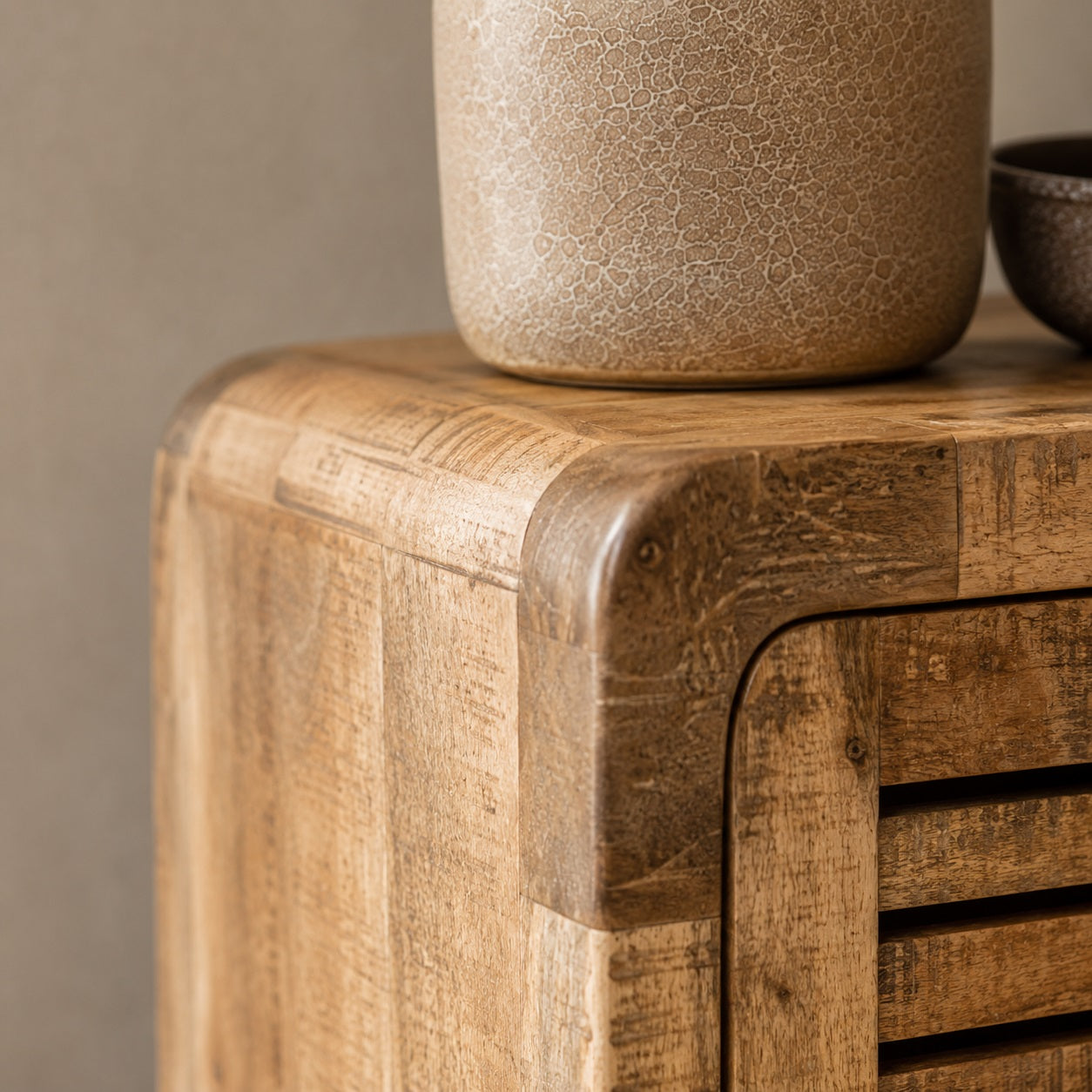 Gros plan sur les finitions d'une table de chevet en bois avec rangement au design soigné et arrondi.
