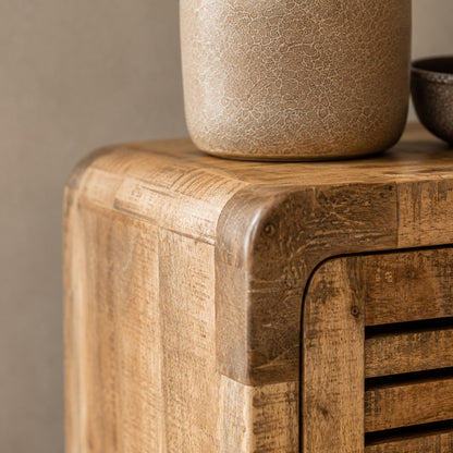 Gros plan sur les finitions d'une table de chevet en bois avec rangement au design soigné et arrondi.
