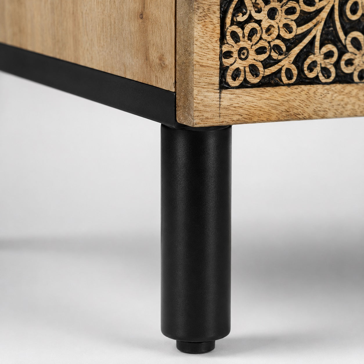 Détail des pieds d'une table de chevet design avec tiroir, alliance du bois naturel et du métal noir.