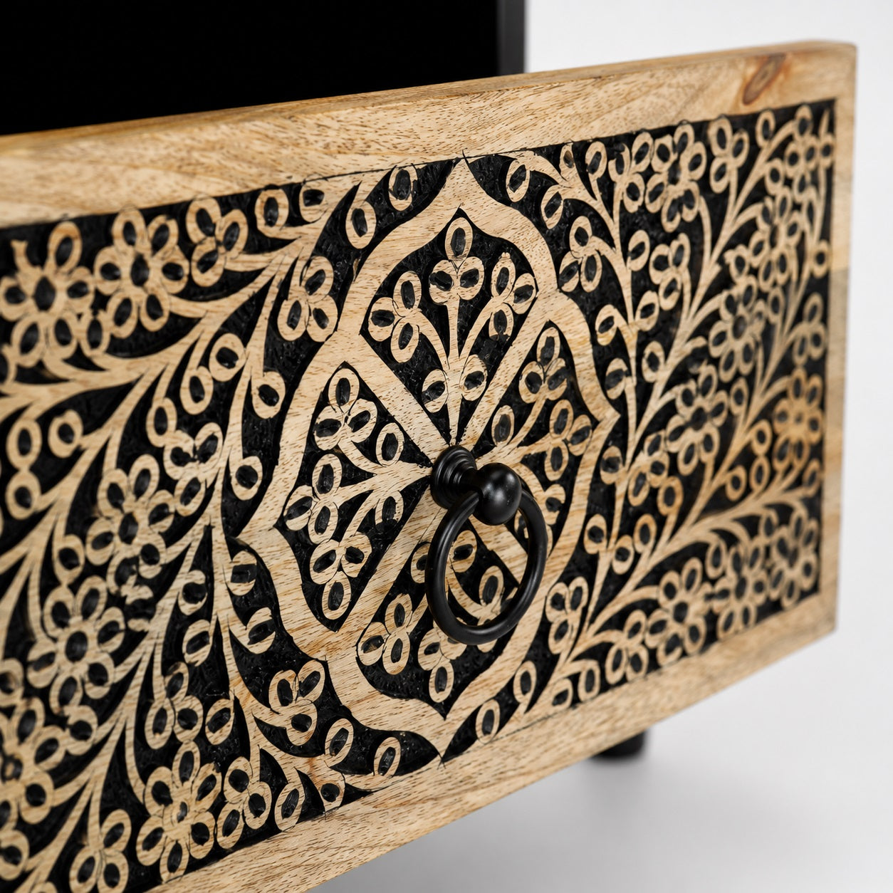 Zoom sur le tiroir sculpté d'une table de chevet design en bois, finition soignée et élégante.