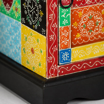Détail d'une table de chevet design en bois avec motifs peints à la main et finition artisanale colorée.