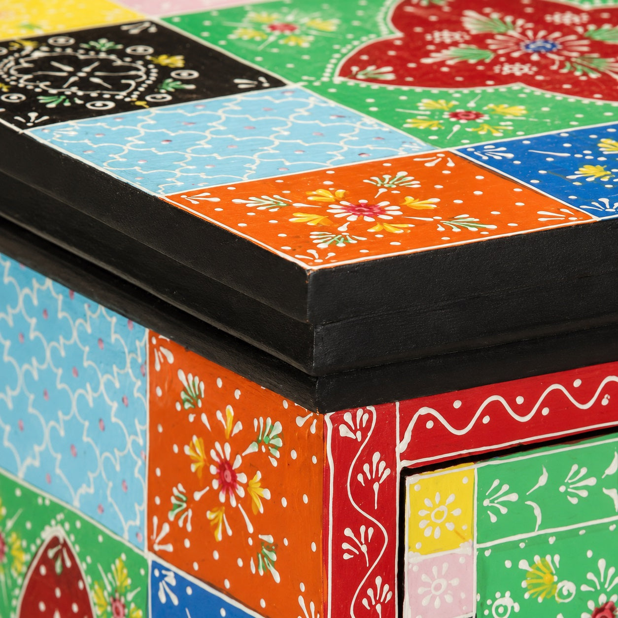 Zoom sur le plateau d'une table de chevet design en bois avec motifs colorés et finition artisanale peinte.