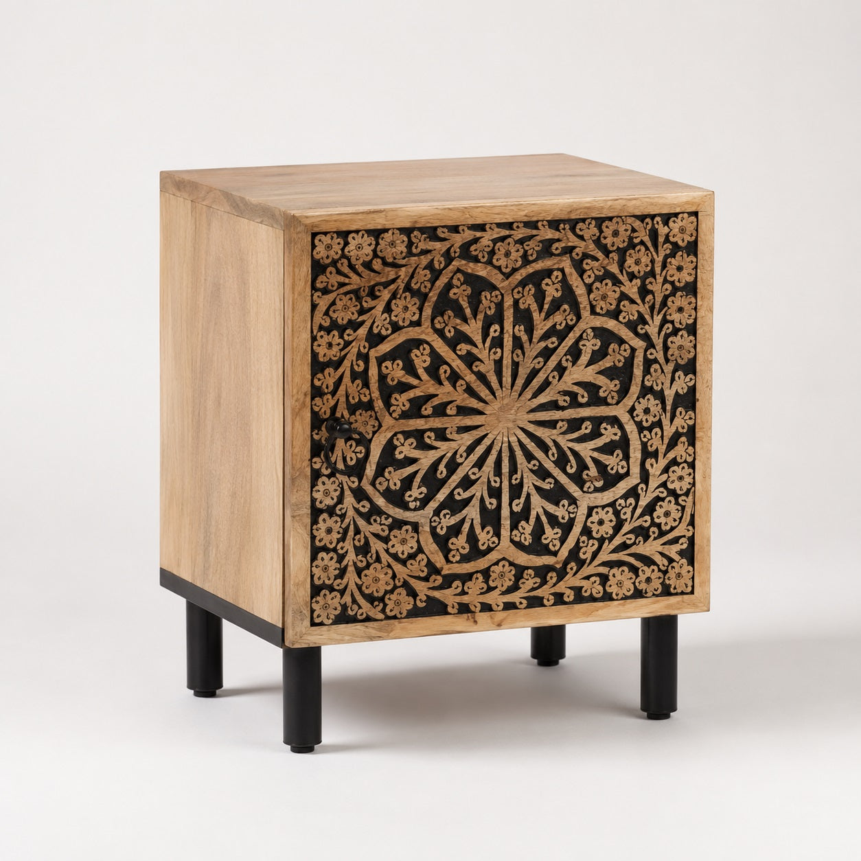 Table de chevet en bois design avec façade sculptée florale, style bohème chic et pieds en métal noir.