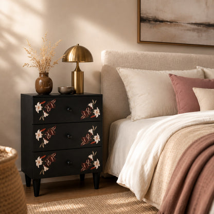 Table de chevet noire design avec motifs floraux près du lit dans une chambre contemporaine.
