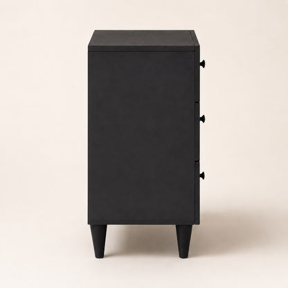 Vue de côté d'une table de chevet noire design à trois tiroirs avec pieds fuselés modernes