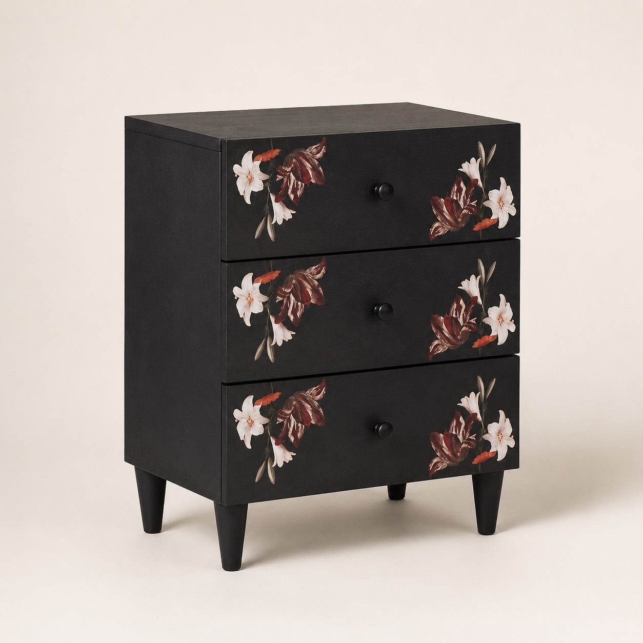 Table de chevet noire design à trois tiroirs avec motifs floraux, idéale pour une chambre élégante.