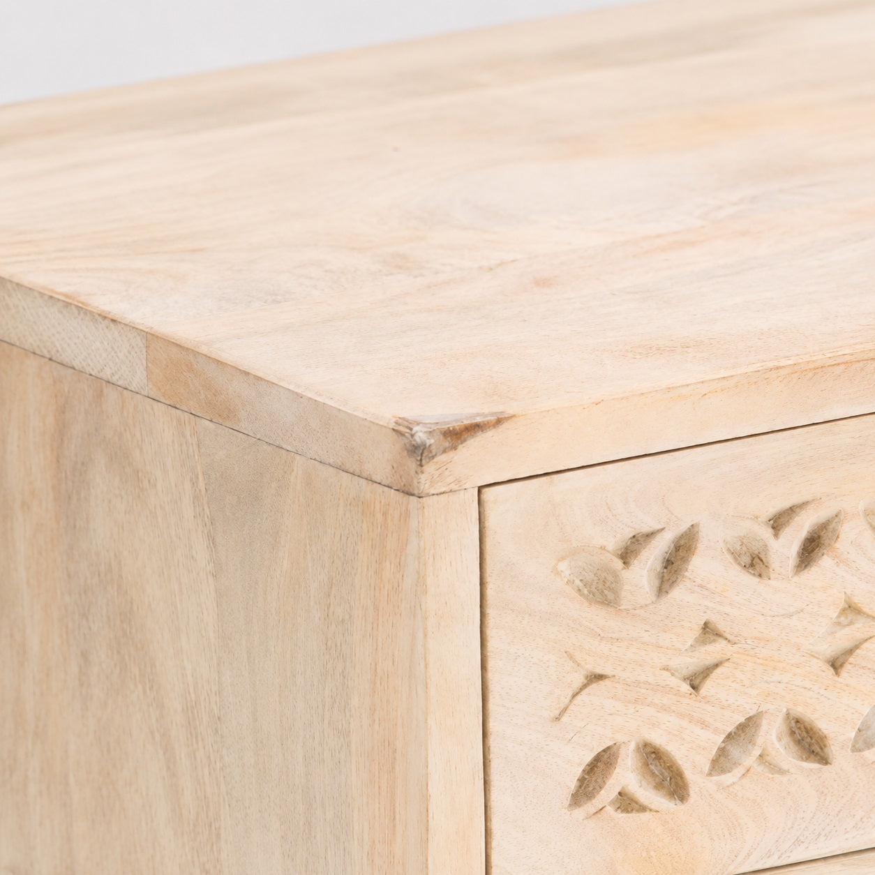 Détail de la table de chevet design en bois sculpté, finition artisanale et tiroir élégant.