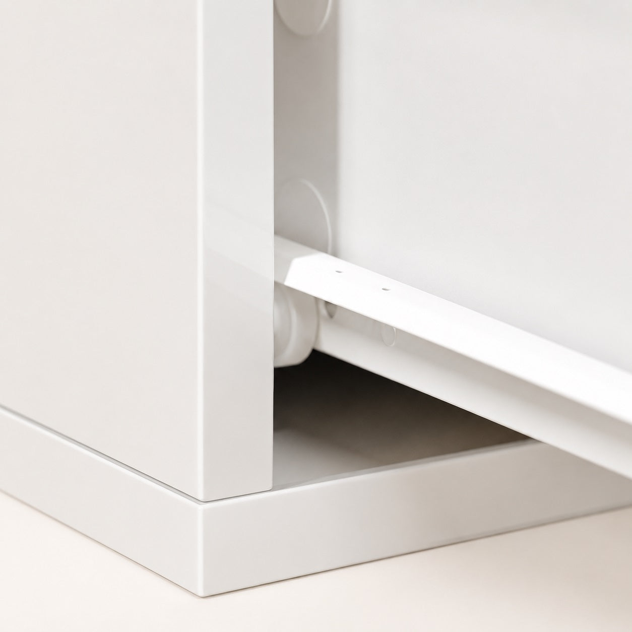 Gros plan sur le tiroir d'une table de chevet suspendue blanche avec système de rangement discret.