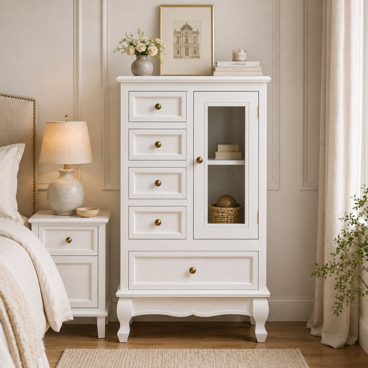 Commode vintage blanche vue de face dans une chambre raffinée, avec 5 tiroirs et porte vitrée.