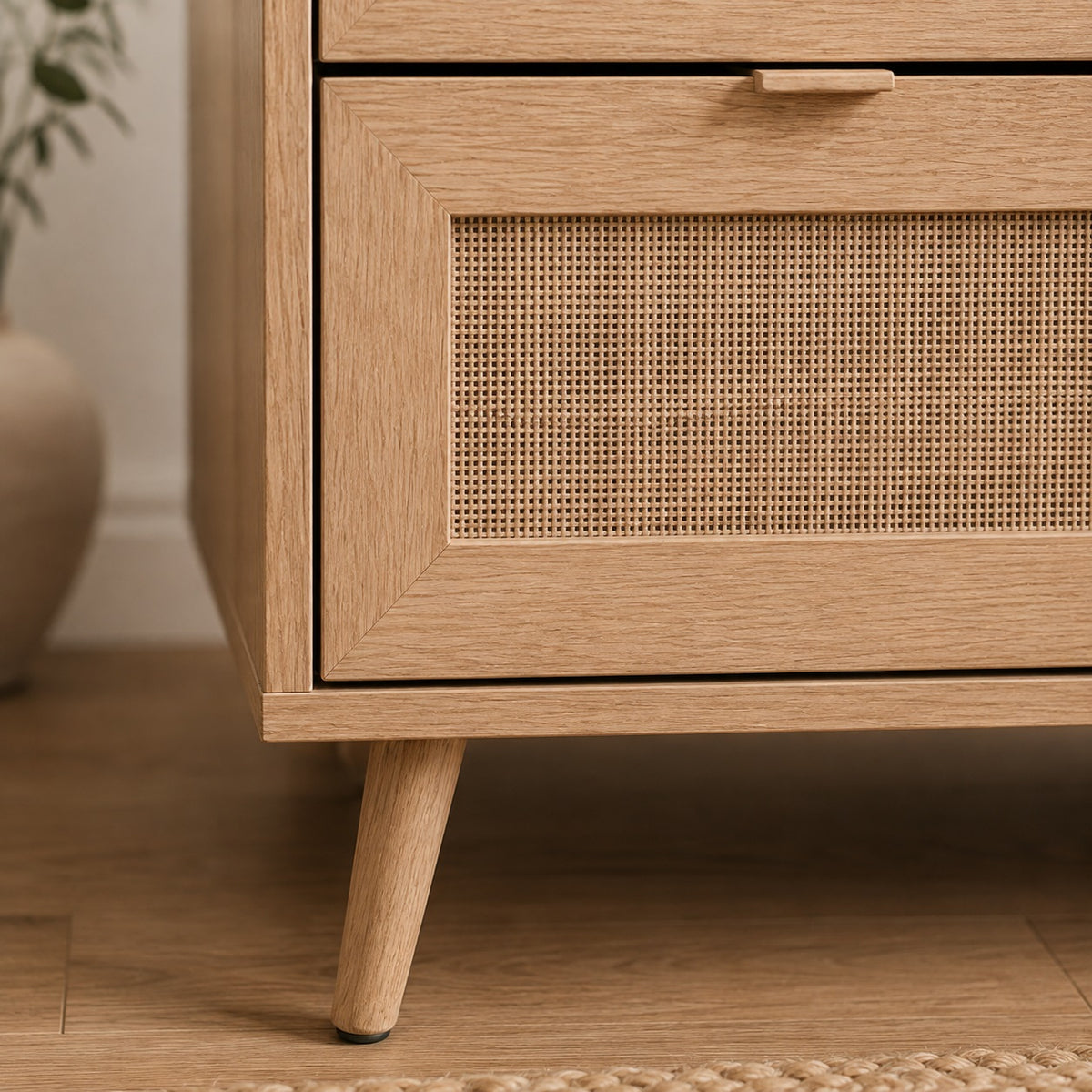 Détail du pied en bois d’une commode design, commode 3 tiroirs avec façade en cannage