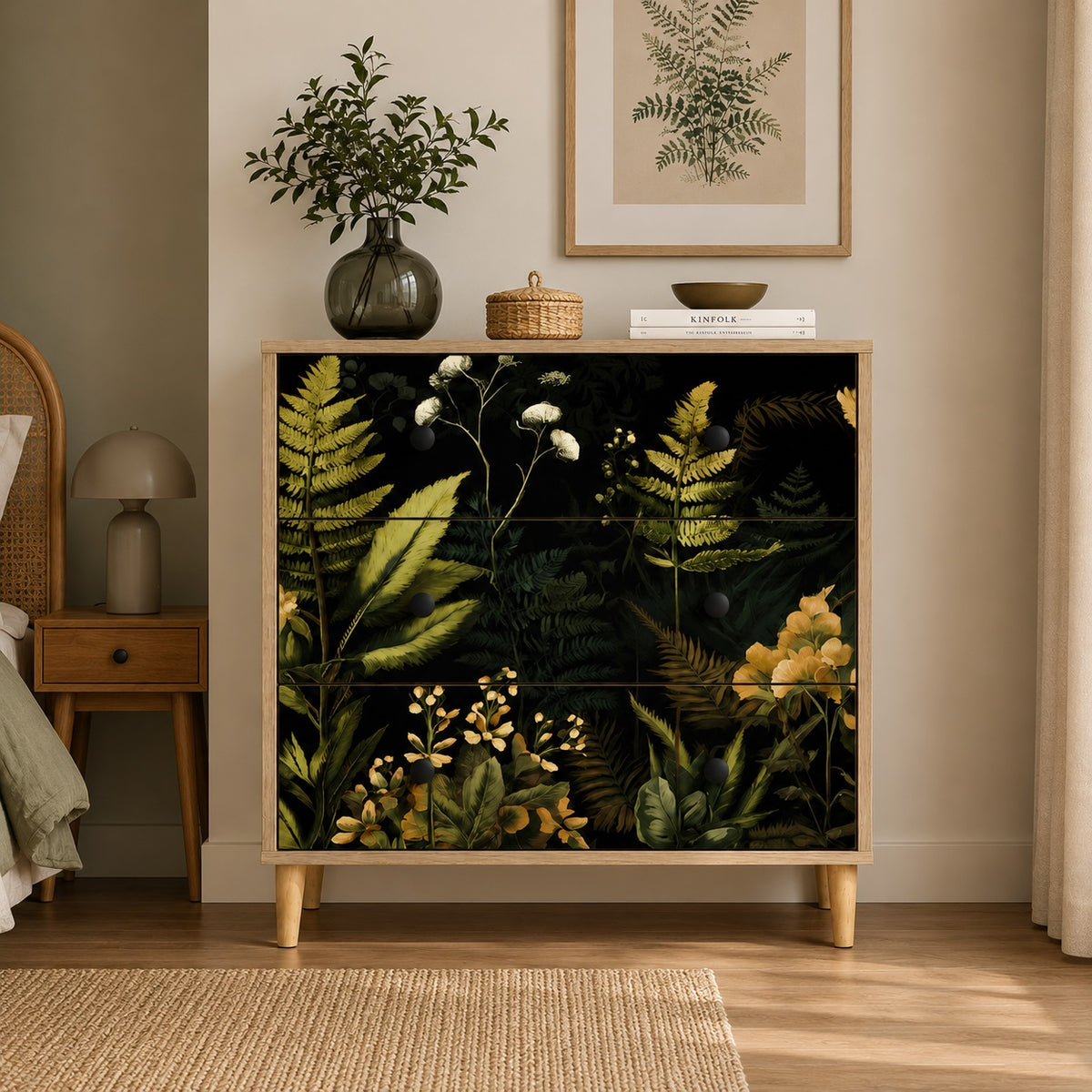 Commode 3 tiroirs Celia vue de face dans une chambre naturelle, commode design à décor botanique sombre.