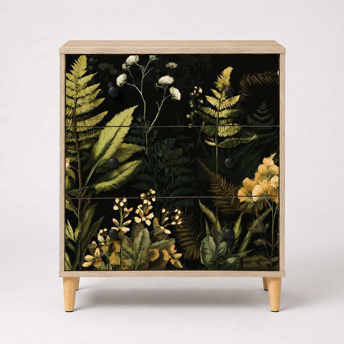 Commode 3 tiroirs Celia vue de face, commode design en bois clair avec élégantes façades végétales noires.