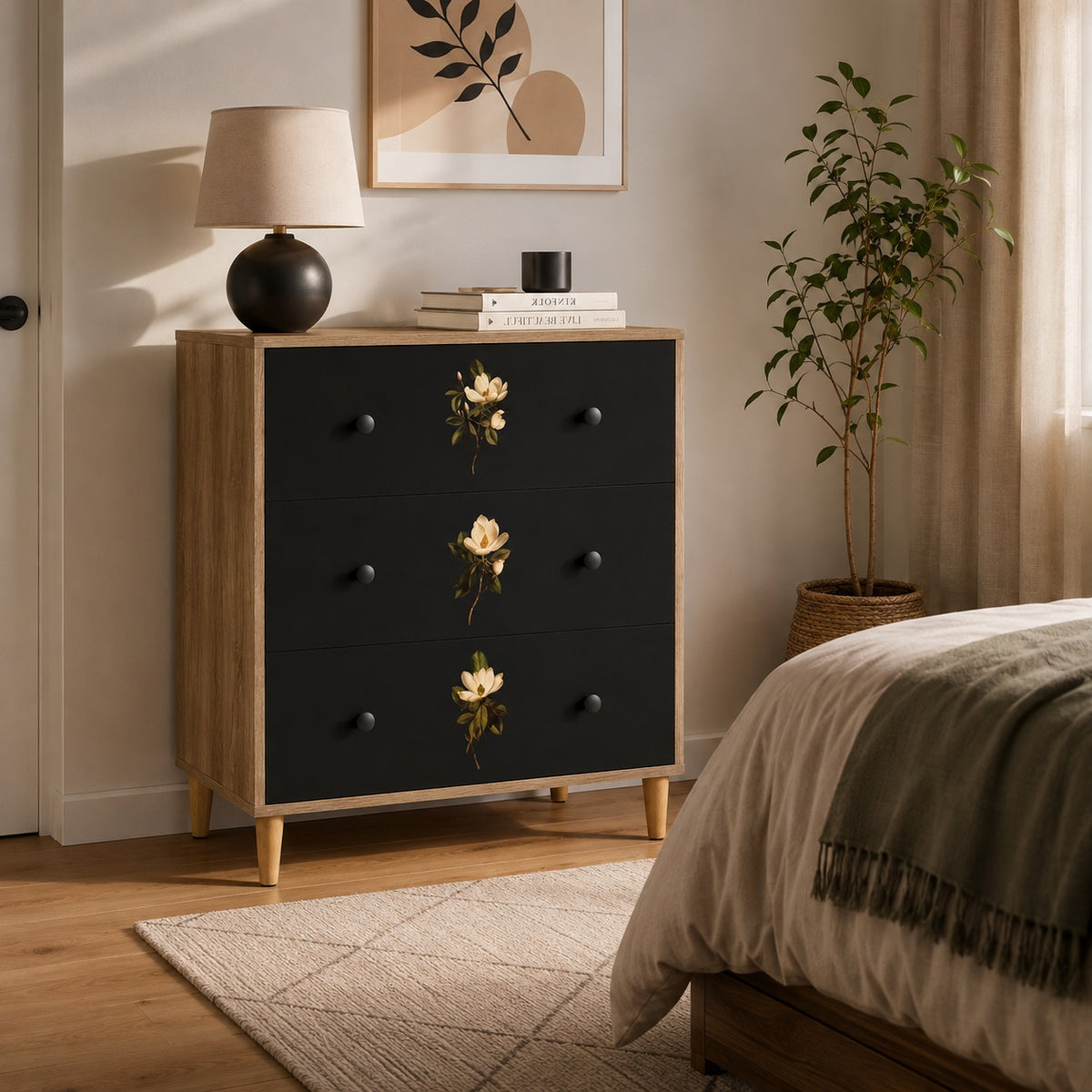 Commode design Celia à 3 tiroirs dans une chambre chaleureuse, avec façades noires et motifs floraux élégants.