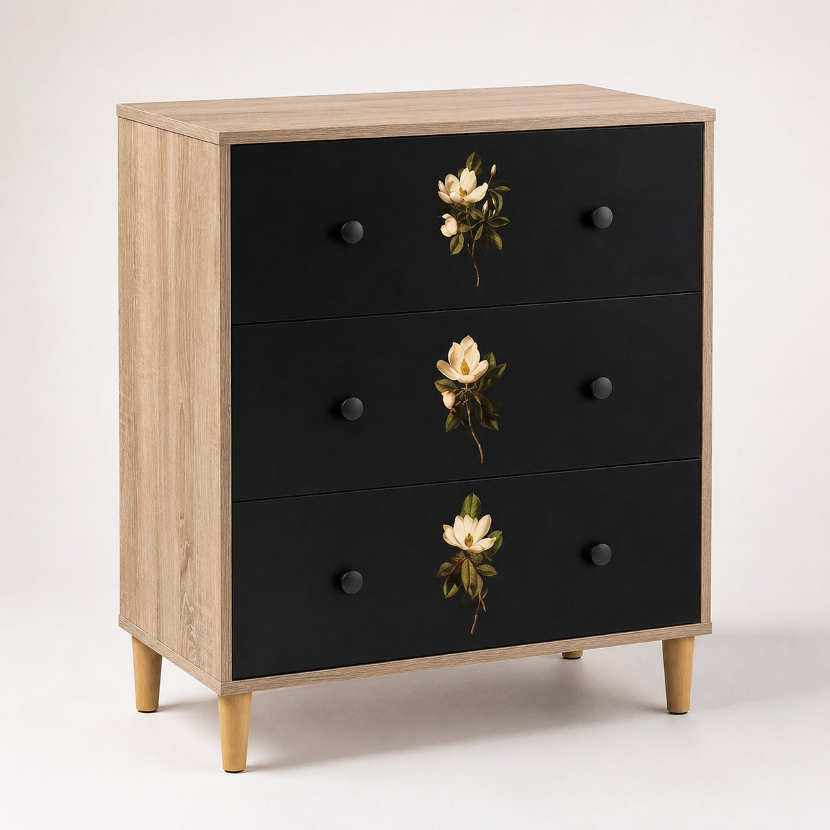 Commode 3 tiroirs Celia noire et bois clair, commode design ornée de délicats motifs floraux sur les façades.