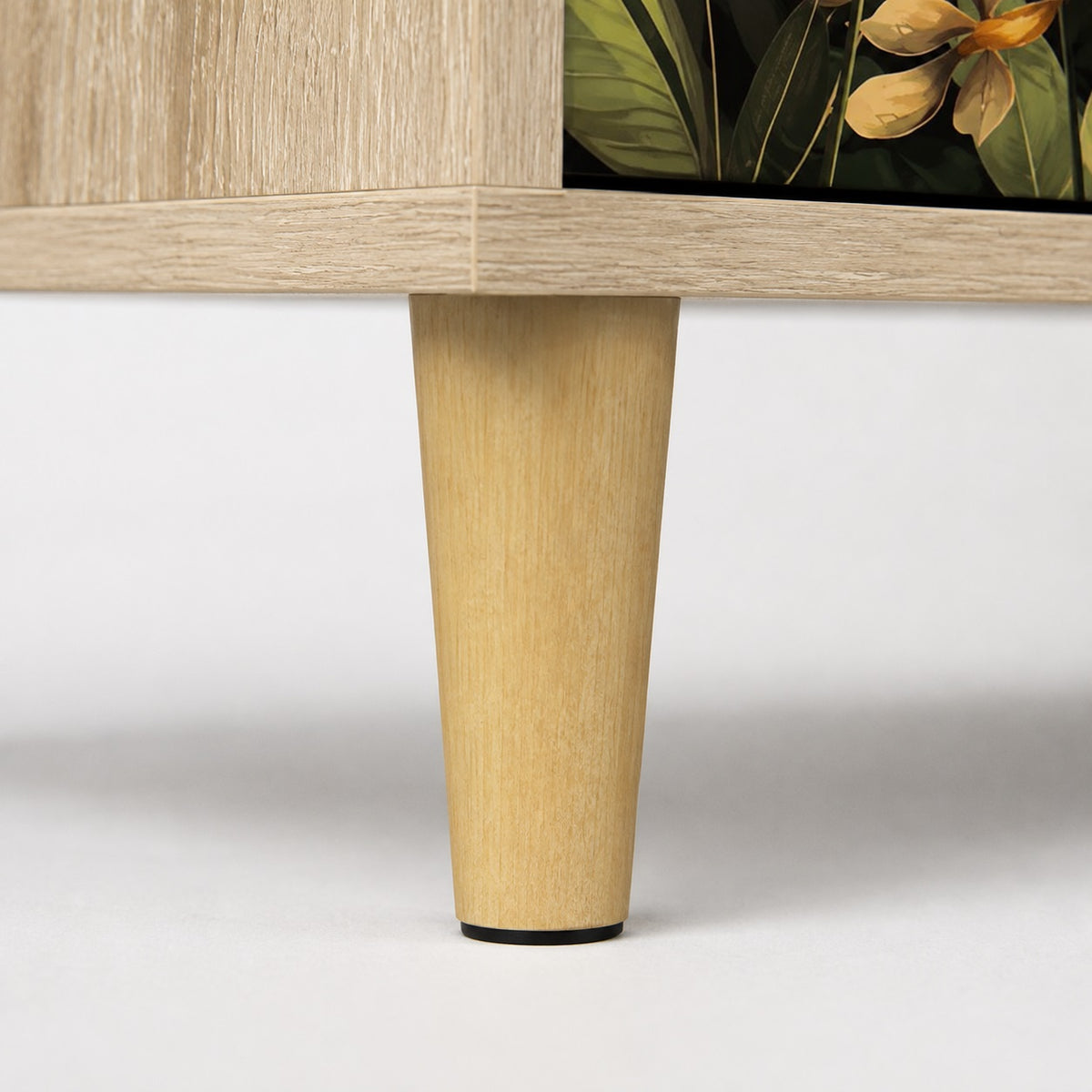 Détail du pied en bois clair de la commode 3 tiroirs Celia, une commode design au style naturel et élégant.