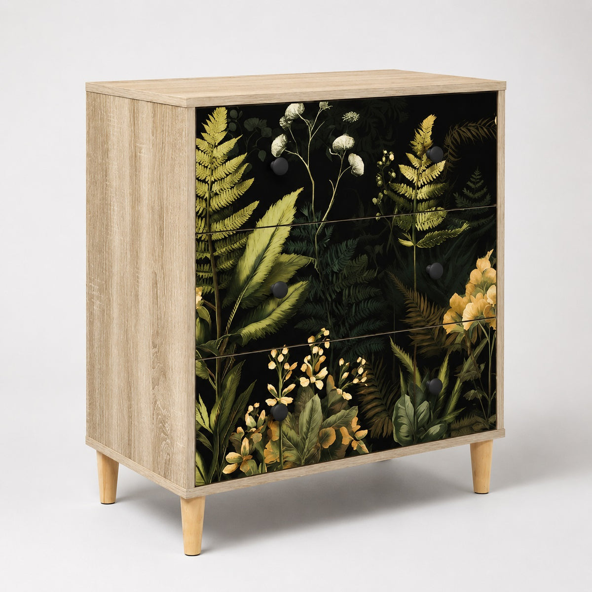Commode 3 tiroirs Celia au design végétal, commode design en bois clair avec façades noires fleuries.