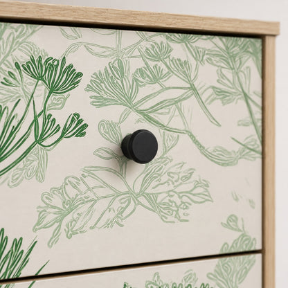 Zoom sur la commode design Dalia, ses motifs floraux verts et ses poignées rondes noires.