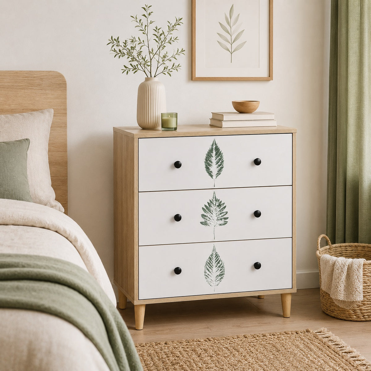 Commode 3 tiroirs design dans une chambre naturelle, avec façades blanches décorées de motifs végétaux.