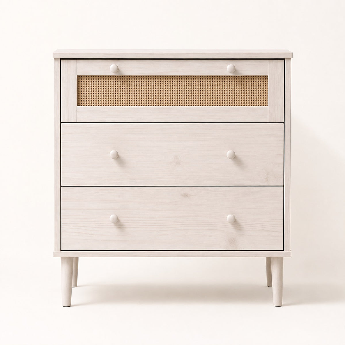 Commode en rotin 3 tiroirs blanche vue de face, avec cannage naturel et poignées rondes.