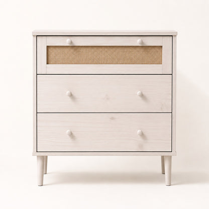Commode en rotin 3 tiroirs blanche vue de face, avec cannage naturel et poignées rondes.