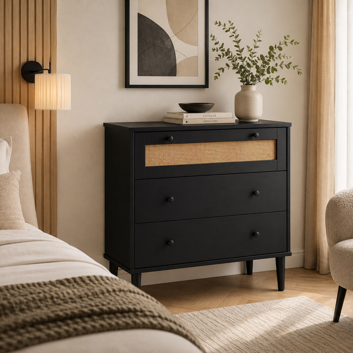 Commode 3 tiroirs noire en rotin naturel, mise en scène dans une chambre élégante et chaleureuse.