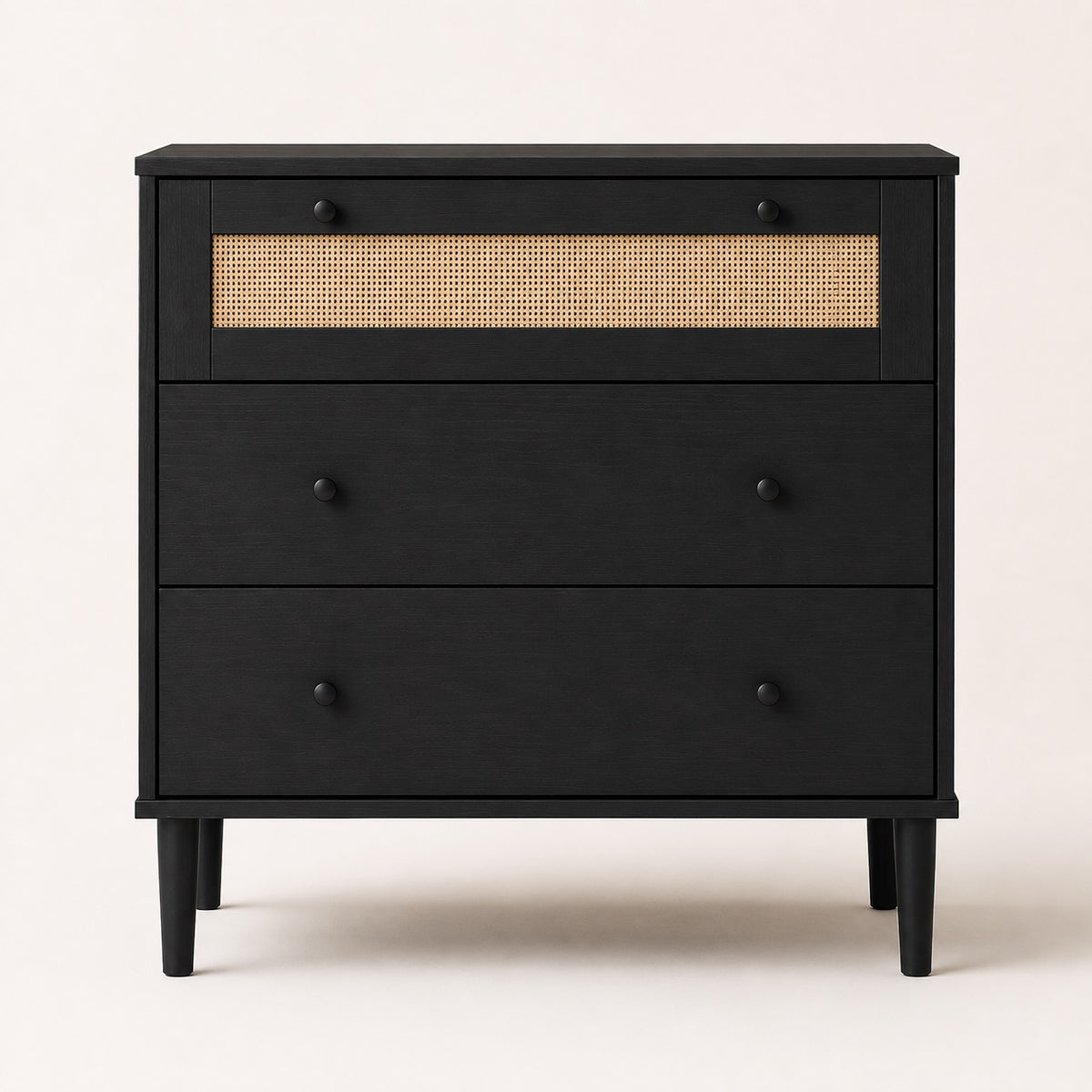Commode en rotin noire à 3 tiroirs vue de face, avec cannage naturel, poignées rondes et pieds surélevés.