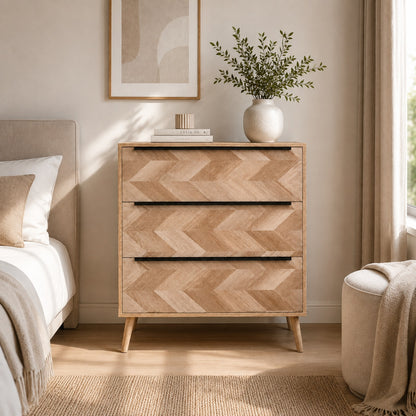Commode 3 tiroirs design en bois clair mise en scène dans une chambre élégante aux tons naturels.