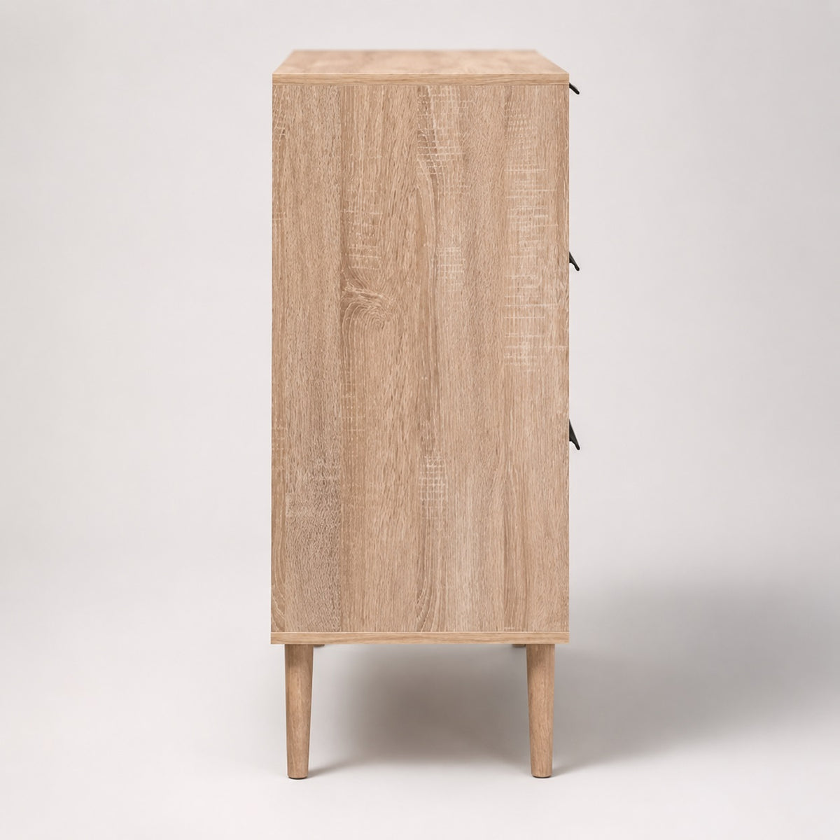Vue de côté d’une commode 3 tiroirs en bois clair, au format compact et au design scandinave.