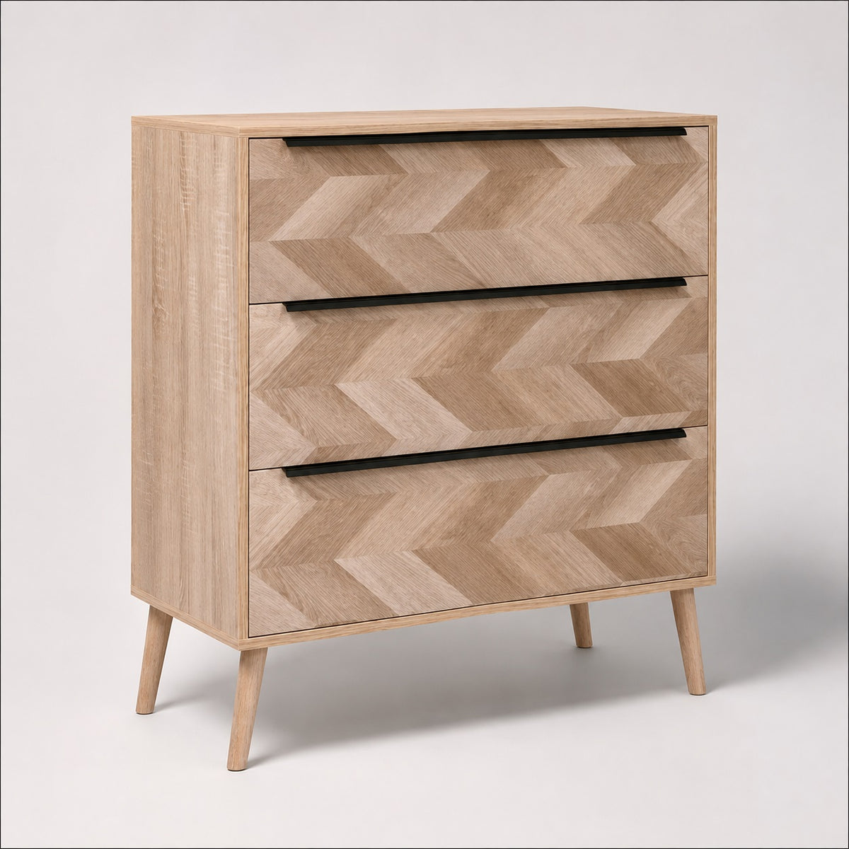 Commode 3 tiroirs design en bois clair, façades graphiques et longues poignées noires au style contemporain.