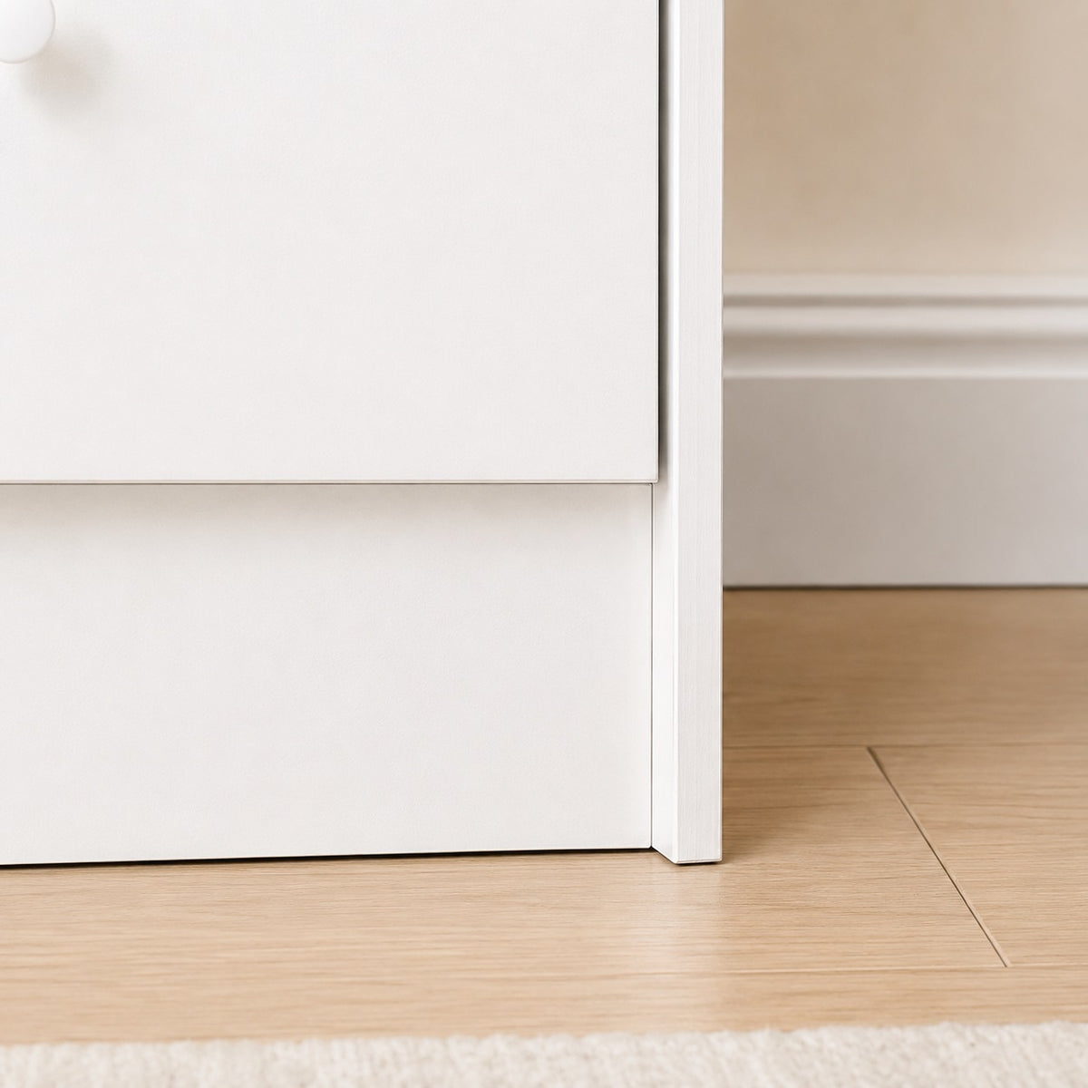 Détail de la structure de la commode blanche 7 tiroirs avec finition élégante et lignes épurées.
