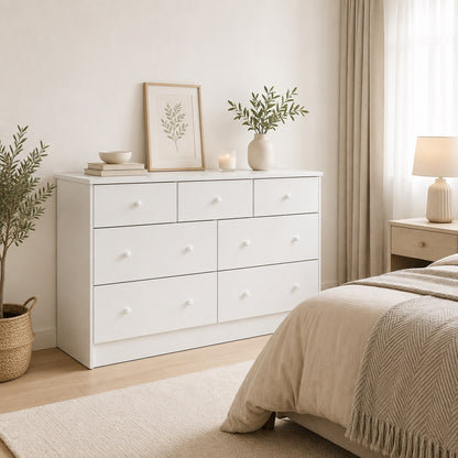Commode blanche 7 tiroirs dans une chambre moderne, offrant un rangement spacieux et un style épuré.