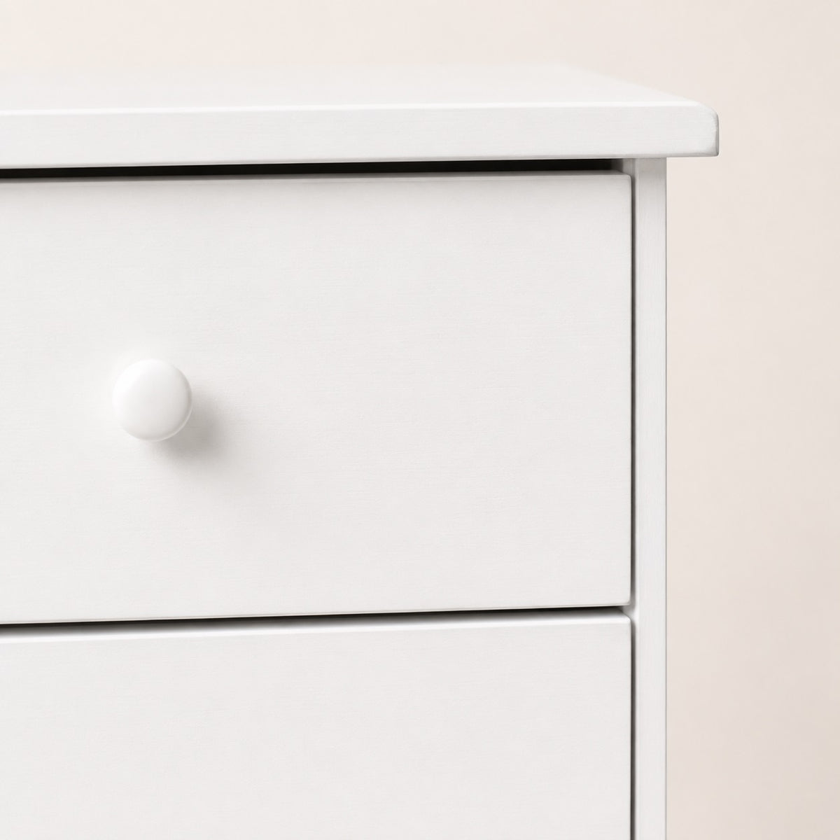 Zoom sur la poignée ronde de la commode blanche 7 tiroirs avec finition élégante et moderne.