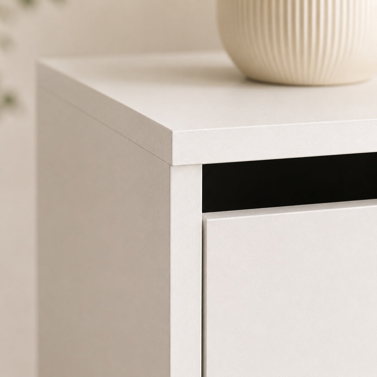Détail de la finition soignée d'une commode blanche 4 tiroirs au design moderne et minimaliste.