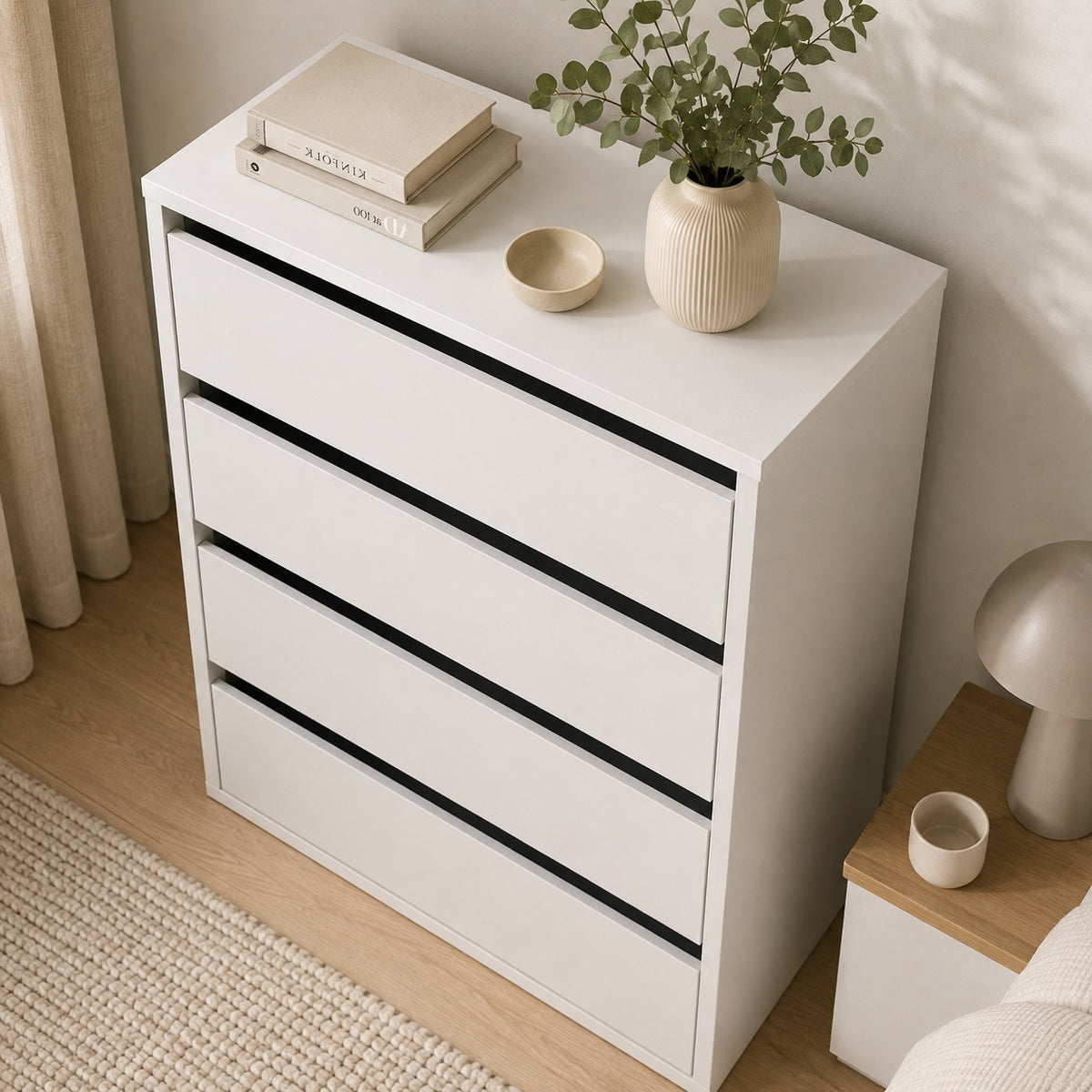 Vue dessus d'une commode blanche 4 tiroirs mettant en valeur son plateau spacieux et son design épuré.