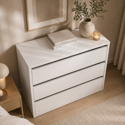 Commode blanche 3 tiroirs avec plateau spacieux et décoration sobre dans une chambre.