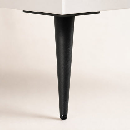Détail du pied noir incliné de la commode 6 tiroirs blanche, pour un style moderne et épuré.
