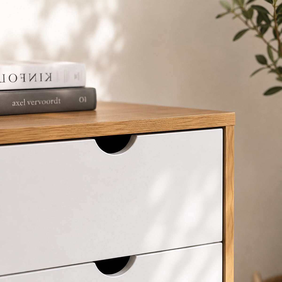 Détail des tiroirs d'une commode blanche en bois avec poignées intégrées et finition scandinave soignée.